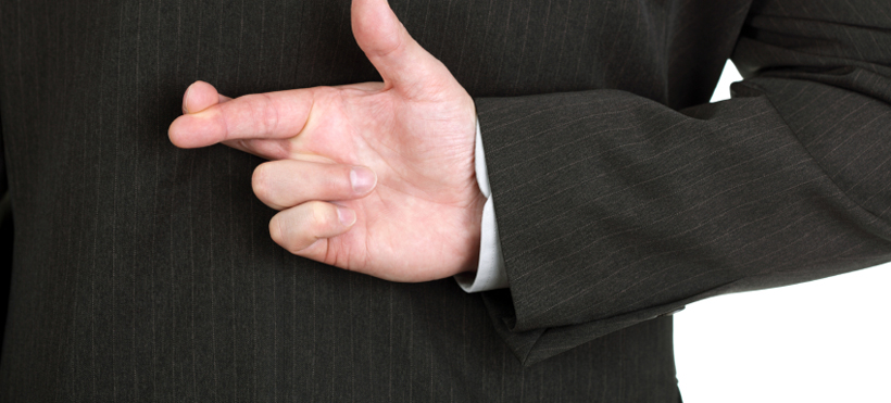 Businessman with his fingers crossed behind his back - concept for good luck or dishonesty